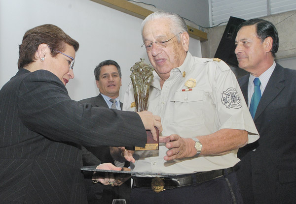 Dra. Yamileth González premia al representante del Cuerpo de Bomberos