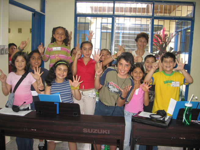 Niños posando frente a pianos