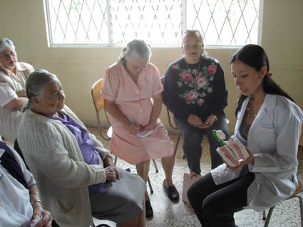 Estudiante explicando a adultos mayores sobre el cepillado