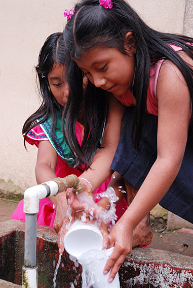 Niñas indígenas lavando vasos