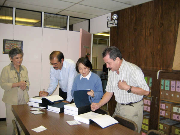 Académicos firmando documentos 