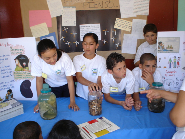 Niños exponiendo sobre ciencia en puesto de exhibición 
