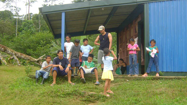 Estudiantes y niños frente a escuela.