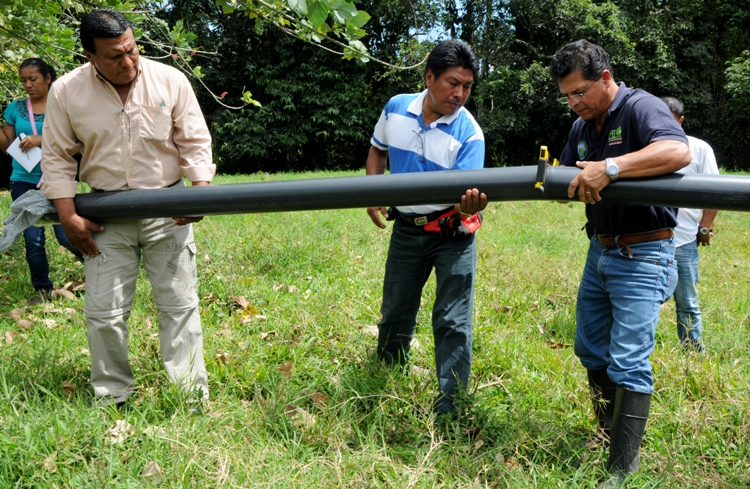 Personas cortando tubo de pvc