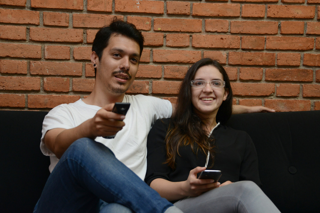 En la fotografía una pareja  ve televisión. 