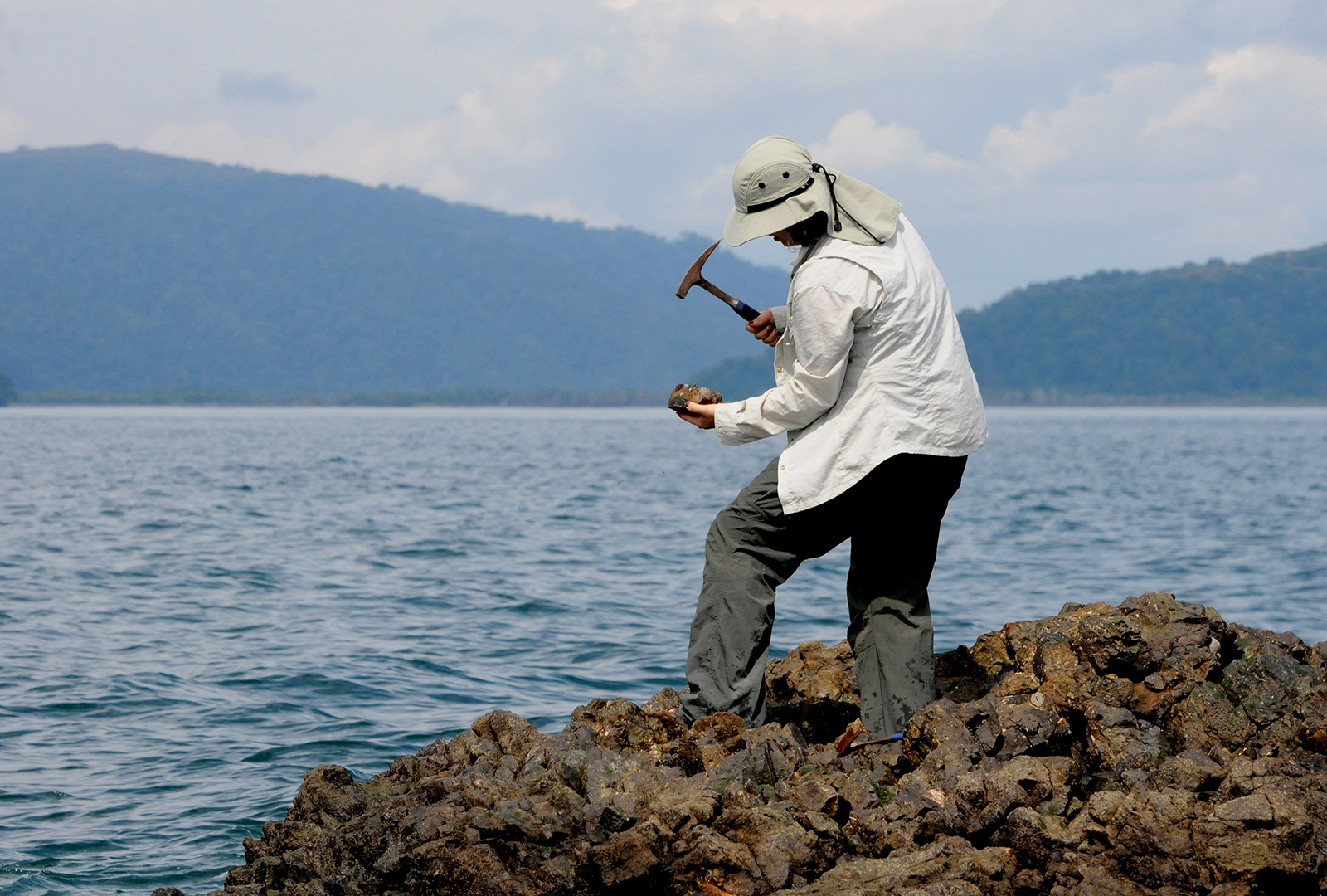 Mujer explora rocas en la playa