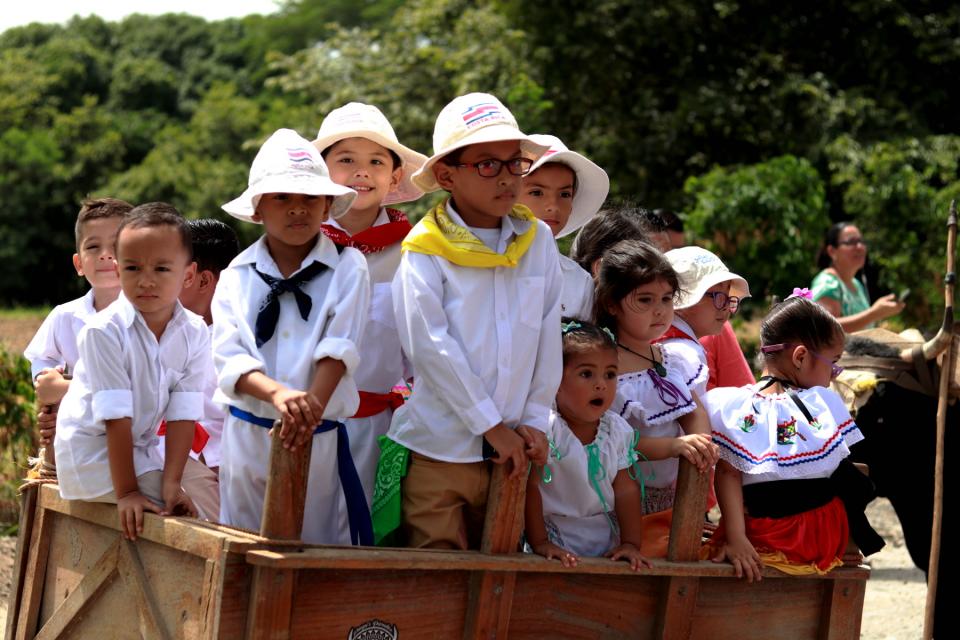 Niñas y niños del Centro Infantil participan en el desfile sobre una carroza