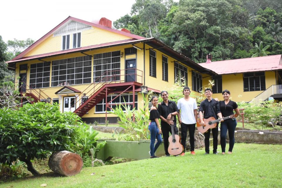 Jóvenes integrantes de la rondalla posan con sus instrumentos frente a las instalaciones del …