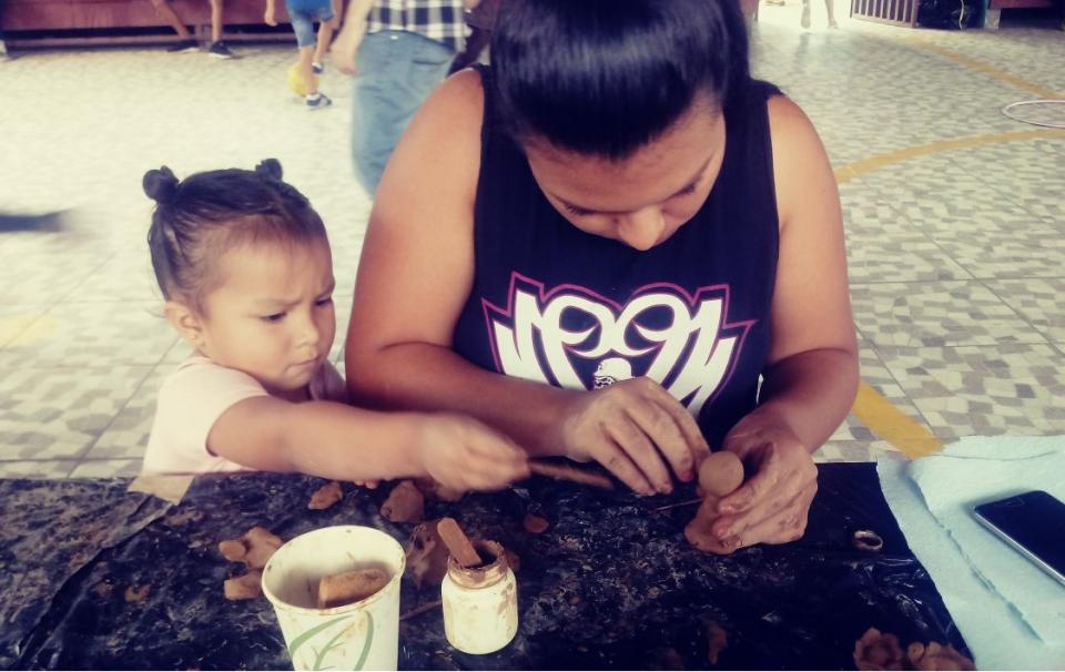 Una niña y su madre hacen figuras de arcilla