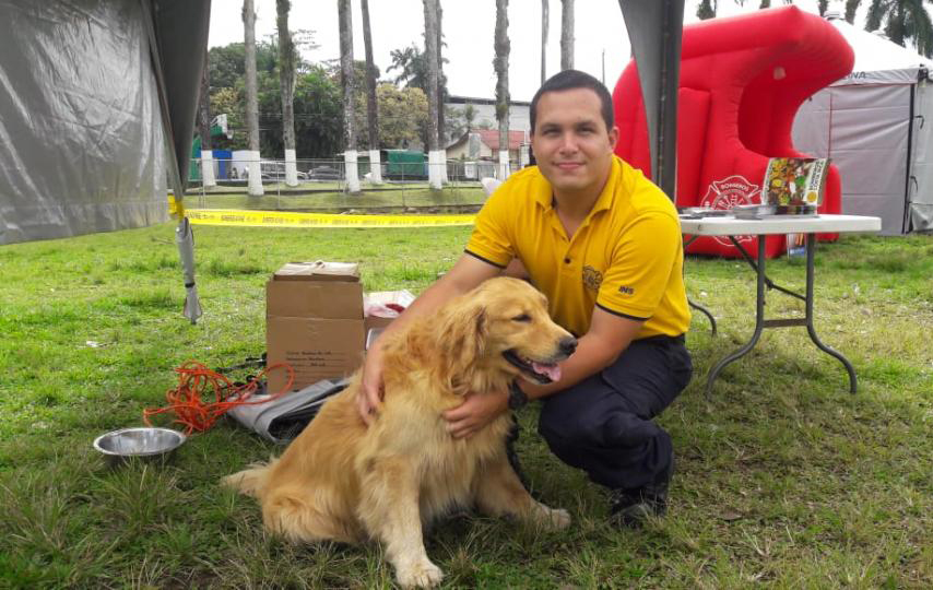 Joven bombero acaricia a su perro en el parque de Guápiles