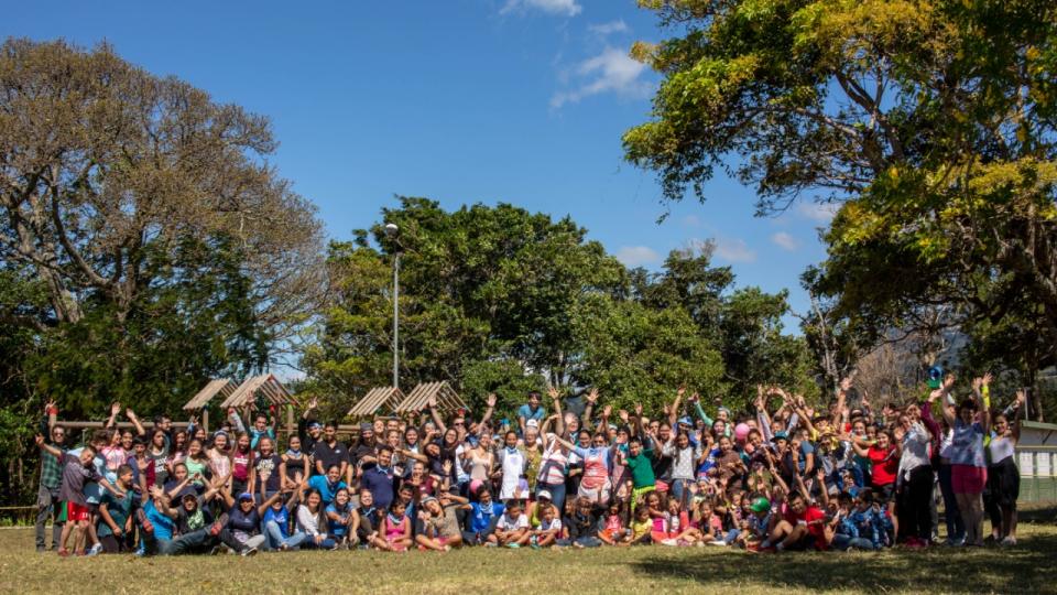 Todos las personas participantes del Campamento posan entre dos árboles