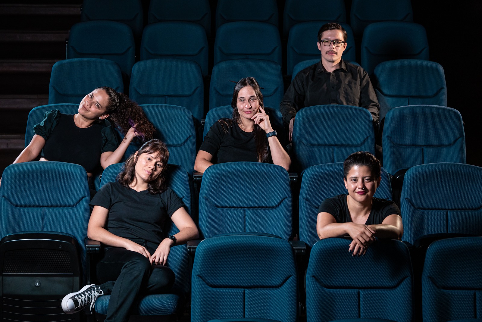 Elenco de la obra sentado en butacas del teatro