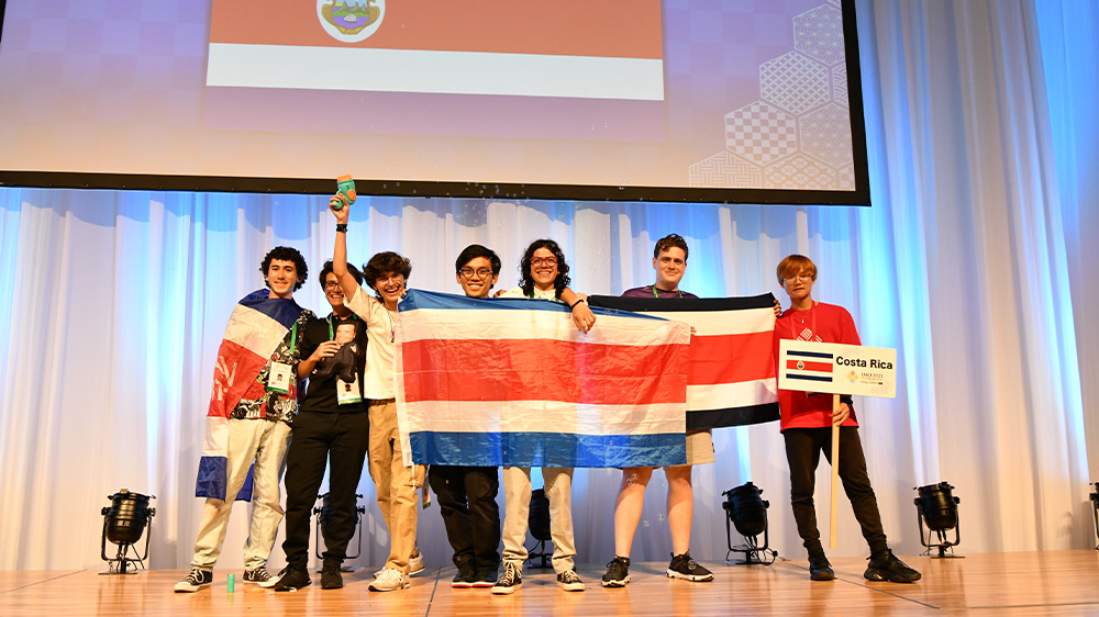 seis estudiantes con la bandera costarricense representando al país en las olimpiadas de …