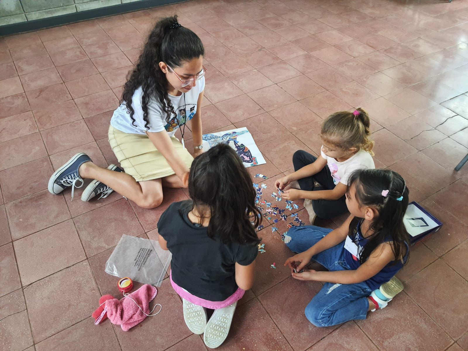 Una joven estudiante de TCU juega con niños en el piso
