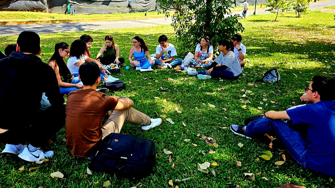 Grupo de jóvenes y líderes comunitarios reunidos en un parque
