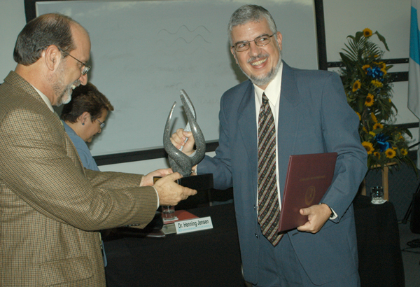 El Dr. Jose Maria Gutierrez recibe del Vicerrector Henning Jensen la estatuilla del escultor …