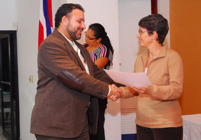 Uno de los funcionarios cooperativistas capacitados recibe su certificado de parte de la doctora …