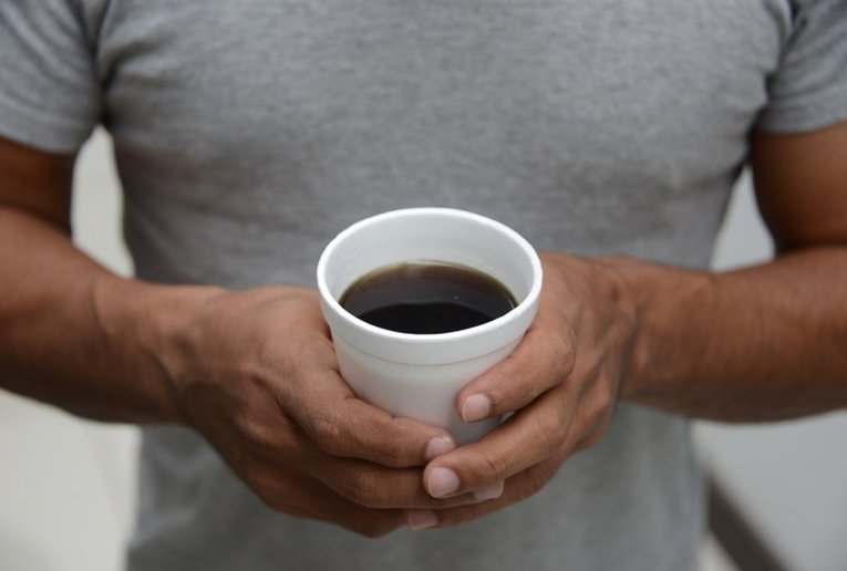 Hombre con vaso de estereofón en las manos