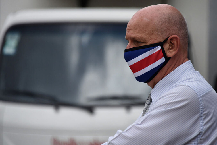 Hombre en la calle con mascarilla con la bandera de Costa Rica