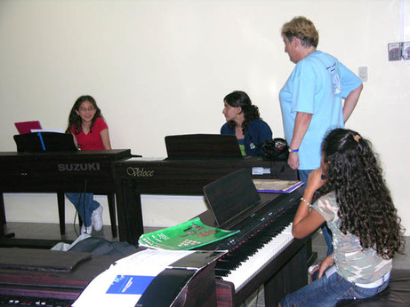 La profesora Sara Feterman junto a tres participantes en el campamento de piano del año pasado.