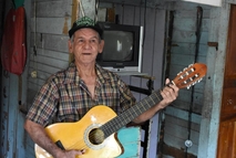 Don Carlos posa con su guitarra en su casa de habitación