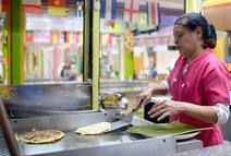 Mujer cocinando tortillas con queso
