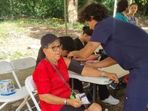 Estudiante realiza medición de la presión arterial a mujer adulta mayor