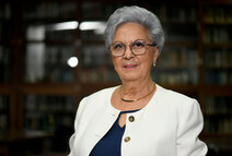 Plano medio de Sonia Jones León en la biblioteca de la Facultad de Letras